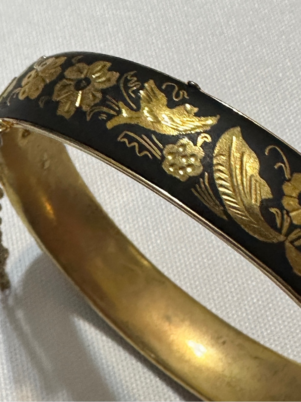 Vintage black and gold-toned hinged bangle bracelet featuring traditional look